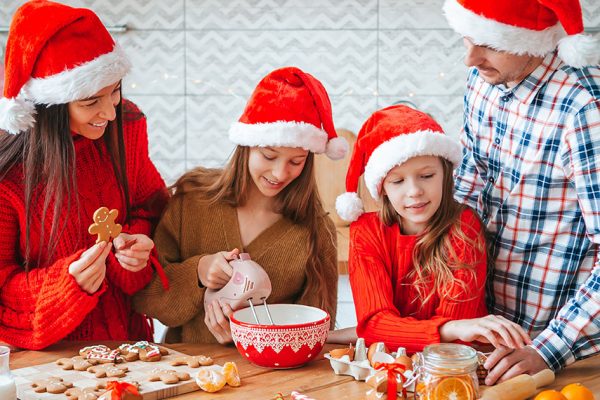 Familia disfrutando de cocinar galletas en Navidad
